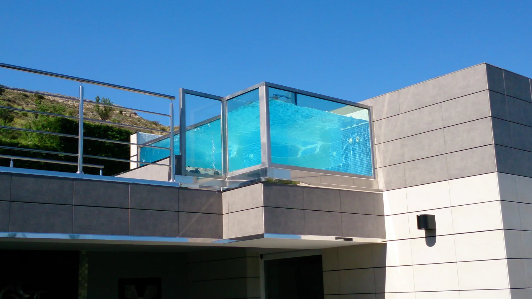 Piscina de cristal construida en una terraza elevada