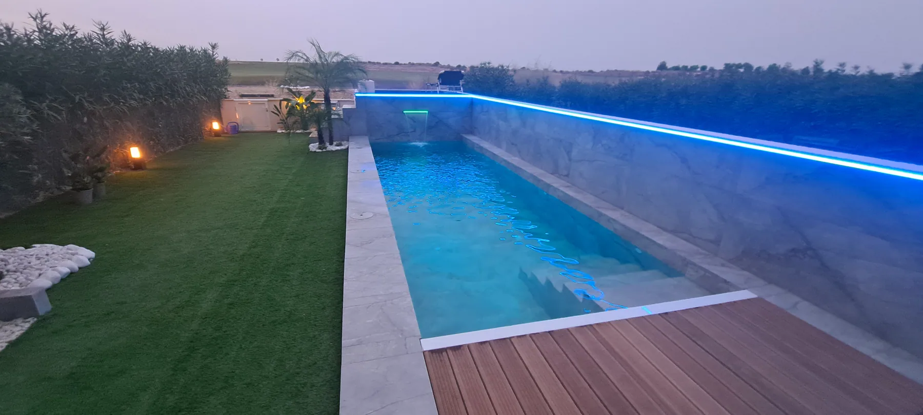 Piscina de obra con iluminación lineal nocturna